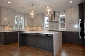 Modern kitchen lighting pendants are also best to give that ultra modern look to your kitchen. Modern Kitchen With Waterfall Countertop Pendant Lights Over Island And White Upper Affordable Kitchen Lighting Kitchen Lighting Design Under Cabinet Lighting