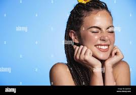 Close up portrait of happy beautiful girl laughs and smiles, showing  excitement and joy, close eyes from happiness, stands over blue background  Stock Photo