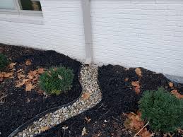 Draining water away from your home starts with you don't want any water going back against the house, since this drains through most of the pipe. Added River Rock To Create A Natural Downspout How Do I Keep Water Away From The House Though Landscaping