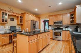 The kitchen has quartz counters, maple cabinets, a white backsplash tile with . Backsplash Paint Ideas For Maple Cabinets And Black Granite Counters