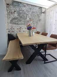 stenen muur behang met houten eettafel net bankje en bruine stoelen boomstam tafel tafel met bankje eettafel