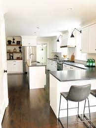 Modern Farmhouse Kitchen White Cabinets With Black Countertops Black Hardware And Kitchen Design Modern White Modern Farmhouse Kitchens White Modern Kitchen