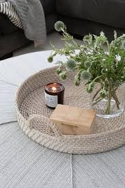 Ottoman coffee tables are cool and pretty easy to work with, especially if you like casual decors because no matter how much you try you could it has a plywood frame which is wrapped in woven banana leaf and four stubby little legs. Round Woven Tray On Round Gray Ottoman As Coffee Table Transitional Living Room