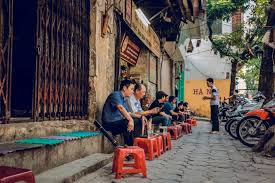 Ghế nhựa thấp và ly cà phê trên vỉa hè Hà Nội