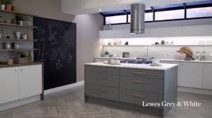 The black mirror chip quartz worktop gives the kitchen a stylish edge whilst the brown oak effect worktop adds an organic element. Lewes Grey And White Shaker Kitchen By Howdens