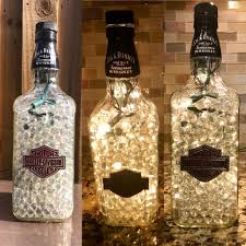 Recycled Jack Daniels Bottle Filled With Clear Lights Clear Marbles Embellished With Metal Harley Davidson Wine Bottle Crafts Bottle Crafts Wine Bottle Diy