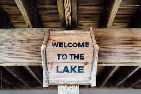 Select size from drop box 14 x 36 (price shown) 17 x 44 (adds $20.00). Wood Welcome To The Lake Sign Under Dock By Deirdre Malfatto