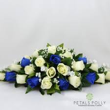 We continue to offer fabulous fresh flower creations to suit every occasion; Royal Blue Ivory Rose Top Table Decoration