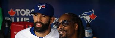 L.A. rapper Snoop Dogg chats in the dugout with Dominican-born baseball  star José Bautista before throwing the ceremonial first