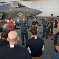 Hull Technician 2nd Class Holly Gardner, left, explains how to don an  Advanced Chemical Protective Garment (ACPG) as Personnel Specialist 3rd  Class Shantrail Robinson demonstrates for a group of Sailors aboard USS