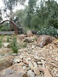 Dry Creek Bed Leading To Fire Pit Area Designed And Constructed By The Team At Abben Art Garden Design Garden Design Drought Tolerant Garden Landscape Design