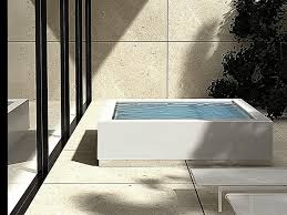 The pool has an irregular curvy shape, and is surrounded by wood decking for a more tropical feel to the pool. Quadrat Minipool Design Ludovica Roberto Palomba