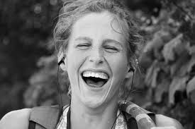 Maya Wallace pauses from skating down 9th Street in Columbia, Missouri  carrying a hula hoop to joke.