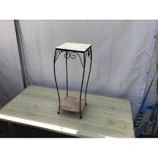 It's made with just wooden dowels and a wood square, making it an easy build that comes together in no time. Wrought Iron Tile Topped Plant Stand