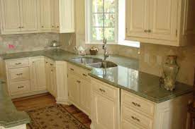 A wall of green cabinets with natural wood shelves adds to this kitchens organic vibe. Kylie M Interiors How To Make Forest Green Work In Your Home Green Kitchen Countertops Green Granite Countertops Kitchen Remodel