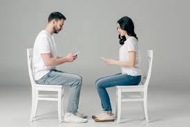 Check spelling or type a new query. Side View Of Concentrated Man And Woman In White T Shirts And Blue Jeans Using Smartphones While Sitting On Chairs On Grey Background Free Stock Photo And Image