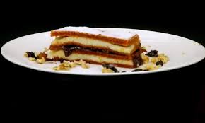 1 ou, 11 linguri zahar, 11 linguri suc de rosii sau bulion putin diluat, 11 linguri ulei, 600 g faina, 1 lingurita bicarbonat, zeama si coaja de la jumatate de lamaie, 1 l lapte, 200 g zahar, 200 g gris, zeama de la jumatate de lamaie, coaja de lamaie sau portocala, 200 g unt. PrÄƒjiturÄƒ Cu Bulion È™i CremÄƒ De GriÈ™ Antena 1