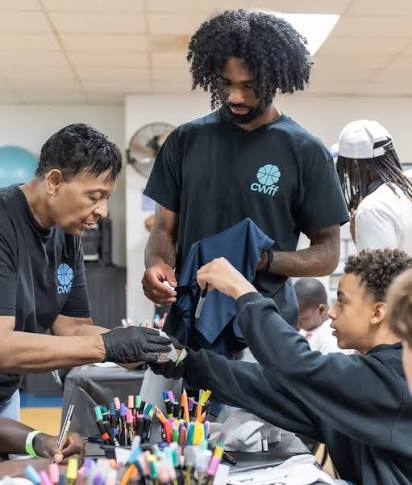 Coby White helping a young attendee customize a shirt at the CWFF Youth Giveback Community Day in Goldsboro