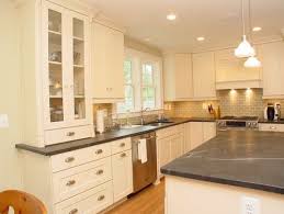 White quartz countertops are somewhat in balance with gray rustic cabinets and wood floors. Cook Bros Of Arlington Va Kitchens Traditional Kitchen Creamy Cabinets Dark Grey Counters Gre Kitchen Design Countertops Kitchen Design Kitchen Remodel