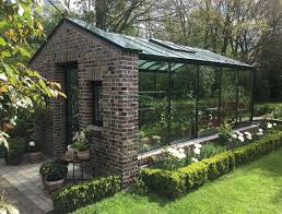 Das Richtige Gewachshaus Fur Balkon Garten Oder Terrasse Very British Wirkt Ein Gartenhaus Mit Natursteinmauer Un In 2020 Garten Gewachshaus Garten Terrasse Garten