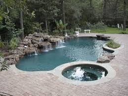 Dazzling Inground Custom Swimming Pool Design With Jacuzzi And Natural Fountain And Stones With Block Pavin Pool Landscaping Luxury Swimming Pools Pool Designs