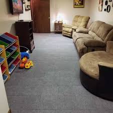 A carpet remnant (permeable) is laid not installed; Basement Modular Carpet Tiles With A Raised Lock Together Base