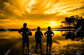 Boy standing under tree sunset hd | try the suggestions below or type a new query above. Three Boys Standing Toward Sun During Sunrise Sunset One Boy Holding A Ball Cloud Tree Reflection On Water Stock Photo Picture And Royalty Free Image Image 43158480
