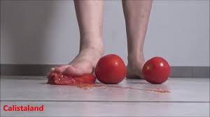 Several tomatoes are crushed under my wonderful bare feet - foot fetish delight!