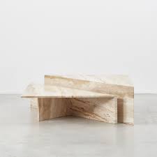 Its sculptural beauty is inspired by the relaxed ambience of 1970's modernism. Travertine Triangle Duo Coffee Table Beton Brut