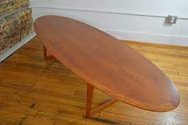 This very long coffee table features raised edges on the two sides that have a slight curve. M M Moreddi Danish Teak Surfboard Coffee Table Galaxiemodern
