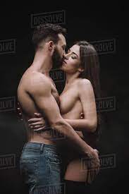 Passionate boyfriend hugging and kissing nude girlfriend, isolated on black  - Stock Photo - Dissolve