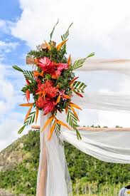 This arch is made of white material and it adopts a nice shape. Tropical Flowers On The Wedding Arch Paradise Cove Island Resort Yasawa Fiji Photograp Wedding Arch Flowers Beach Wedding Decorations Reception Wedding Arch