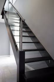 Case Study Stained Black Oak Stainless Steel Glass The side of a staircase open to view which locates the treads and risers.