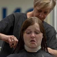A newly-arrived recruit gets her hair cut at the barbershop inside the  Golden Thirteen Recruit In-Processing Center at Recruit Training Command.