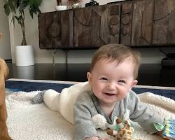 baby and a pet playing togetherの画像