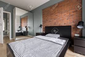 That way you will make wonderful interior design with pleasant charming feel. Modern Bedroom With Brick Wall Mirrored Wardrobe And Bed Stock Photo Picture And Royalty Free Image Image 88153862