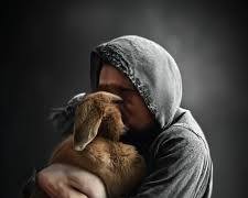 person crying while hugging a pet's photoの画像