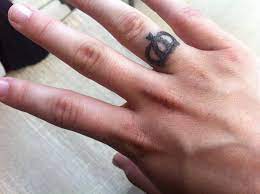 A simplistic black crown is illustrated on the underside of the wearer's ring finger in this tattoo. 40 Ring Finger Tattoos