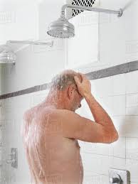 Older man showering in locker room - Royalty-free Stock Photo | Dissolve