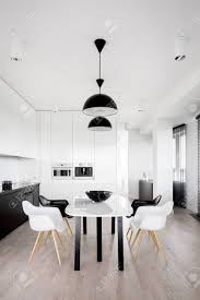 We did not find results for: Modern White Dining Table Under Two Black Ceiling Lamps In Spacious Black And White Kitchen Stock Photo Picture And Royalty Free Image Image 149089175