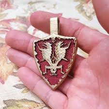 Vicars were the heads of the healing church, as is revealed in the item description for the gold pendant, which she can be seen clutching in the cutscene, and even in battle after her grotesque transformation. Download Bloodborne Cainhurst Badge Von Kevin Ortiz