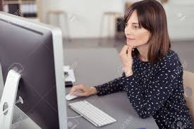 Maybe you would like to learn more about one of these? Pretty Office Woman Sitting At Her Desk Using The Computer While Leaning On Her Elbow Seriously Stock Photo Picture And Royalty Free Image Image 42088289