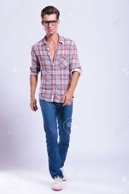 On sidewalk pavement in the city, smiling and looking down, holding on her unbuttoned coat, full length. Full Length Picture Of A Casual Young Man Walking Towards The Stock Photo Picture And Royalty Free Image Image 20304560