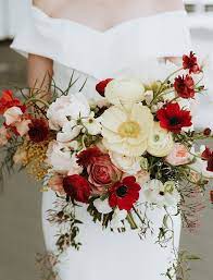 The beauty of red roses, and red rose wedding bouquets, lie in the fact that they beautifully complement all flowers. An Event Planner S Glam Winter Wedding With Pops Of Bright Color Green Wedding Shoes Red Bouquet Wedding Poppy Wedding Bouquets Winter Wedding Bouquet