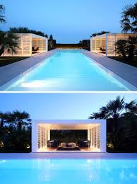 This pool cabana is stocked with all the essentials with an outdoor kitchen, wet bar with sitting area, fireplace and outdoor lounge area complete with plenty of seating. Outdoor Lighting Adds A Dramatic Element To This Modern White House