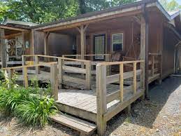 These camping cabins sleep six people in two rooms, one with a double bed and one with two sets of bunk beds. Cabins On The River Campground Near Cherokee North Carolina