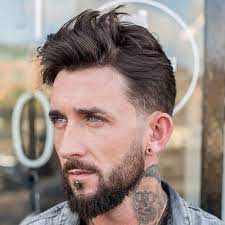 Versatile and fashionable, the low bald fade haircut can be paired with all the best men's hairstyles for a bold look. Low Fade Messy Top Beard
