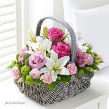Stylish and minimalistic boho interior of living room with wooden furnitures, gray macrame, rattan and elegant accessories. Beautiful Basket Of Flowers Basket Flower Arrangements Flower Arrangements Center Pieces Spring Flower Arrangements