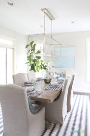 A Coastal Inspired Tablescape With Navy Blue And White Striped Placemats Blue Paisley Napkins Blue Squ Linen Dining Chairs Dining Room Design Driftwood Table