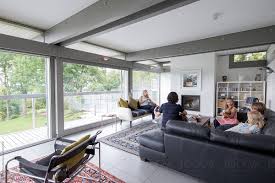 This relaxed grey design features a cosy marble fireplace, brown leather feature chair and most unusual bookcase, which. Family Relaxing Together In Their Modern Living Room By Paul Phillips Stocksy United